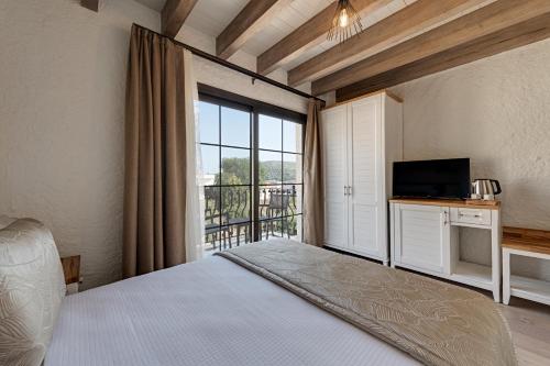 a bedroom with a bed and a large window at Atrium Taş Otel in Cesme