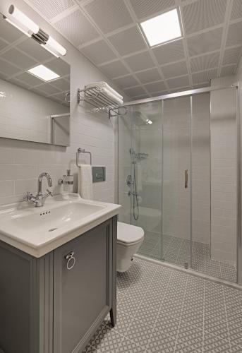 a bathroom with a toilet and a sink and a shower at Atrium Taş Otel in Cesme