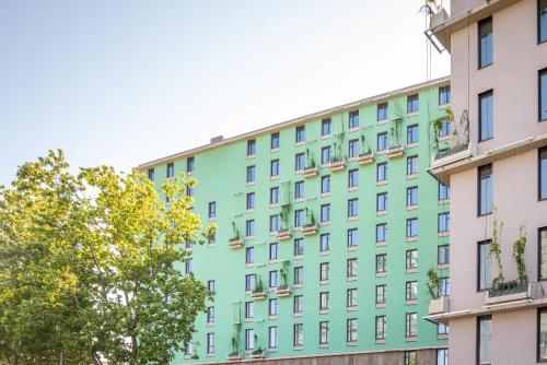 a colorful building with a tree in front of it at Campanile Vienna South in Vienna