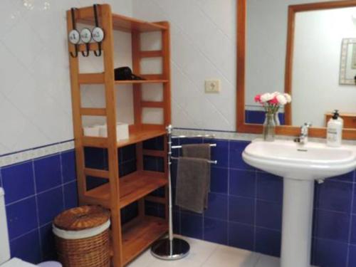 een blauw betegelde badkamer met een wastafel en een houten plank bij Apt Casa Mamen spacious with sea views in Puerto del Carmen