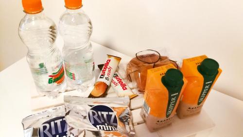 Villa Carmen Resort في كامبوباسو: مجموعة من زجاجات المياه والوجبات الخفيفة على طاولة