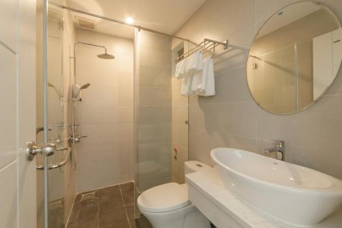 y baño con lavabo, aseo y espejo. en CIEN hotel en Quy Nhon