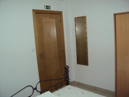 a room with a wooden door and a mirror at Casa do Mosteiro de Refoios do Lima in Ponte de Lima