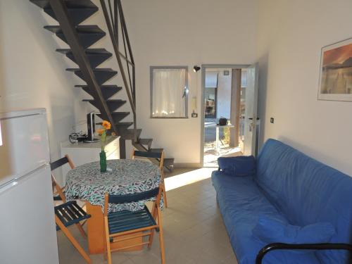 a living room with a blue couch and a table at Appartamenti Villaggio Internazionale in Albenga