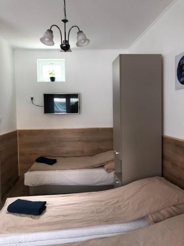 ミシュコルツにあるAvas Apartmanのベッドルーム1室(ベッド2台、壁掛けテレビ付)