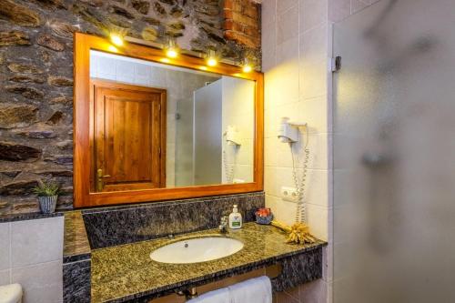 Les Pereres的住宿－卡爾帕斯卡爾酒店，一间带水槽和镜子的浴室