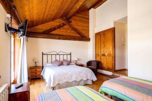 um quarto com uma cama e um tecto de madeira em Cal Pascual em Les Pereres