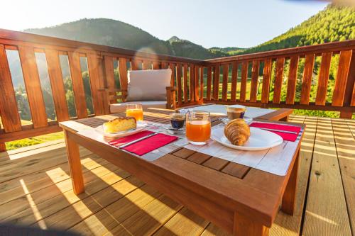 a wooden table with food and drinks on a deck at Hotel Al Foiron in Claviere