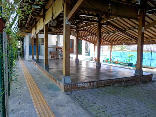 an empty porch of a building with a wooden roof at Griya Jagadhaya in Bantul