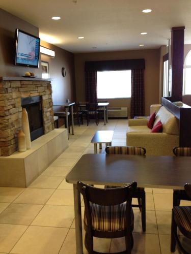 a living room with a couch and a fireplace at Microtel Inn & Suites in Sidney