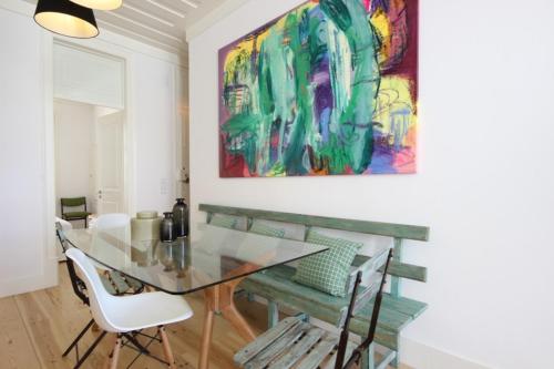 a dining room with a glass table and a painting at The Lookout Duplex - Bairro Alto in Lisbon