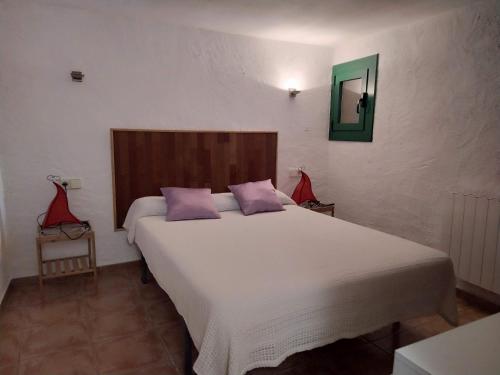 1 dormitorio con 1 cama blanca grande con almohadas moradas en Casa 1872 Fortià-Terraube, en Fortià