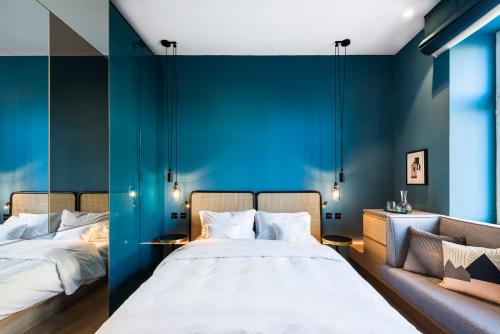 a bedroom with two beds and a couch at Maximilian Hotel in Prague
