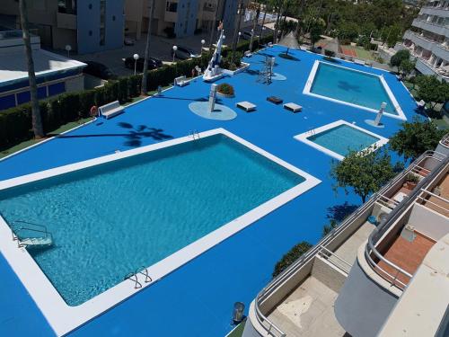 una vista aérea de una piscina de agua azul en SERVICE APART LAZARO- Apartamentos Aguamarina 49, en Calpe