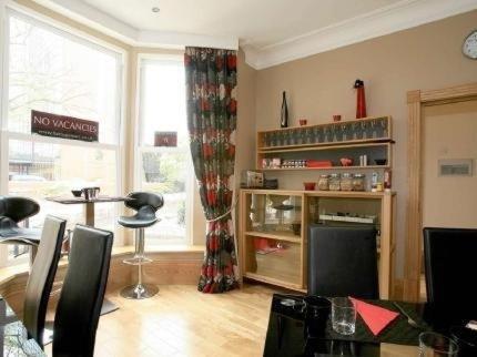 a living room with a table and a window at The Arc - Boutique B&B in Harrogate