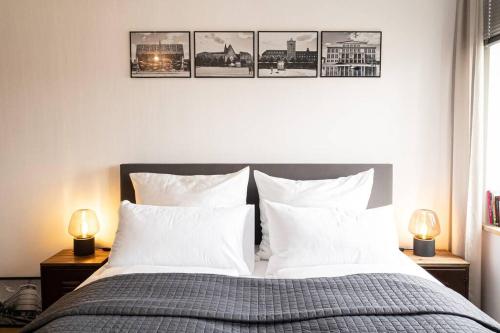 1 dormitorio con 1 cama con 4 cuadros en la pared en Luxus-Apartment in Leipzig mit Privat-Parkplatz en Leipzig