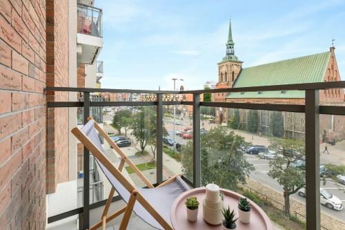 a balcony with a table and chairs and a view of a street at Blue Mandarin Garden Gates in Gdańsk