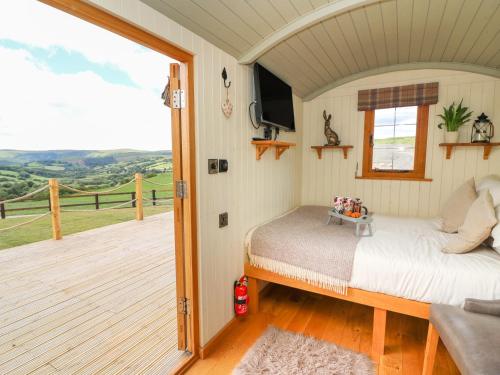 a bedroom with a bed and a balcony at Ivy's Way in Rhayader