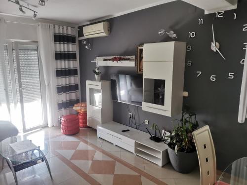un salon avec une horloge murale dans l'établissement Apartment Toni, à Primošten