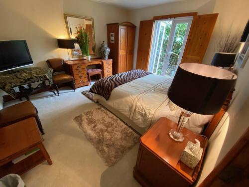 um quarto com uma cama e uma mesa com um candeeiro em The Lodge at Ruddington em Nottingham
