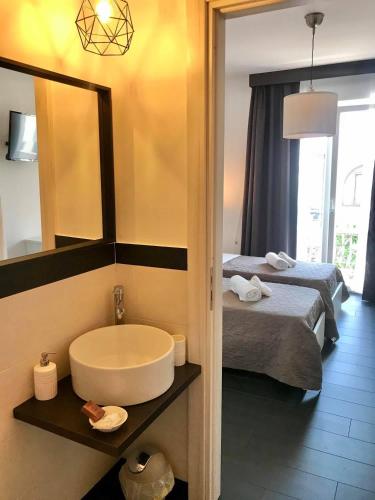 a bathroom with a tub and a bed and a mirror at Bonsai in Tropea