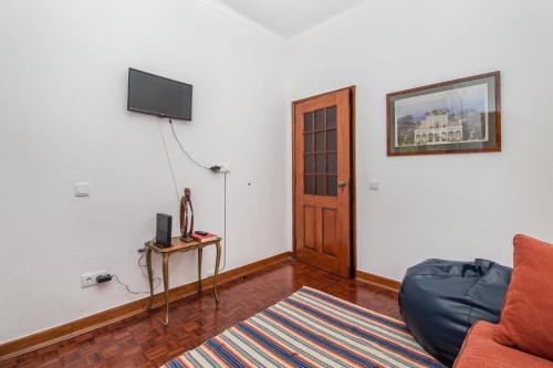 a living room with a couch and a flat screen tv at Casa dos Pais in Silves