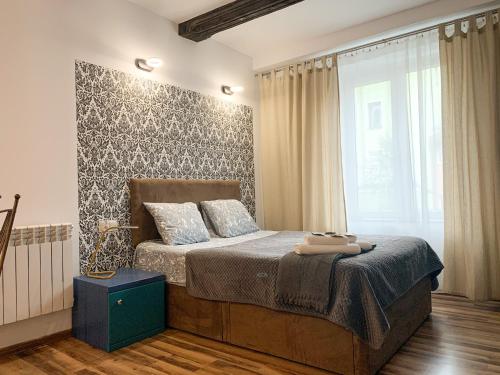 a bedroom with a bed and a large window at Old Town Studio Apartment in Toruń