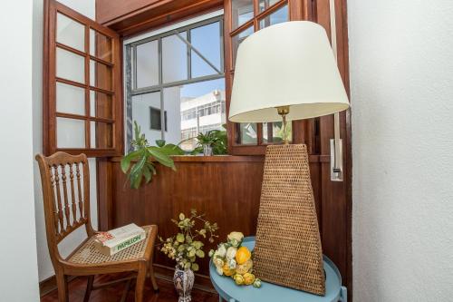 a lamp on a table in a room with a window at Casa dos Pais in Silves
