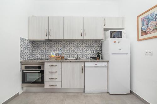 a kitchen with white cabinets and white appliances at Casa dos Pais in Silves