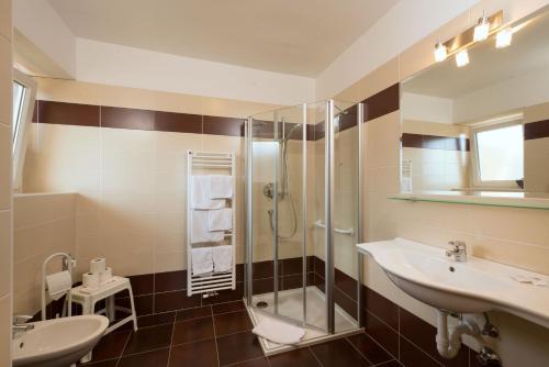 y baño con 2 lavabos y ducha. en Pensione Penegalblick, en Appiano sulla Strada del Vino
