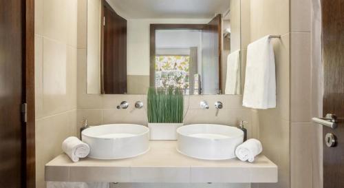 uma casa de banho com 2 lavatórios brancos e um espelho em Novo Apartamento T2 Herdade dos Salgados - Vila das Lagoas em Guia