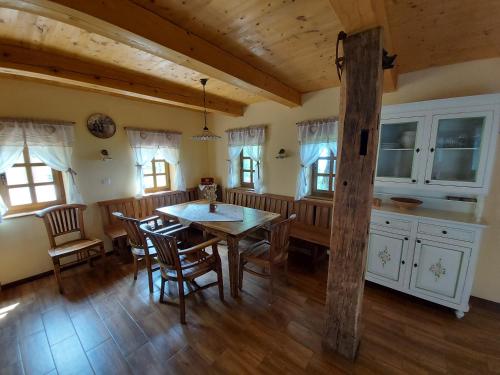 uma cozinha e sala de jantar com uma mesa de madeira e cadeiras em Oldhouse Knezovo em Sromlje