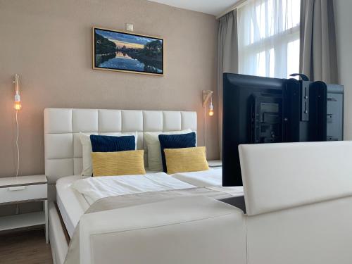 a bedroom with a large white bed with yellow pillows at Hotel van Oppen in Zierikzee