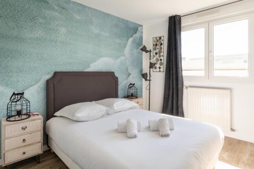a bedroom with a white bed with two pillows at DIFY Desaugiers - Jean Macé in Lyon