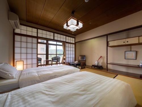 a large bedroom with two beds and a table at Hotel Flags Isahaya Nagasaki in Isahaya