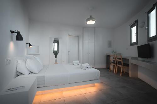 a white bedroom with a white bed and a desk at ZOE in Apollonia