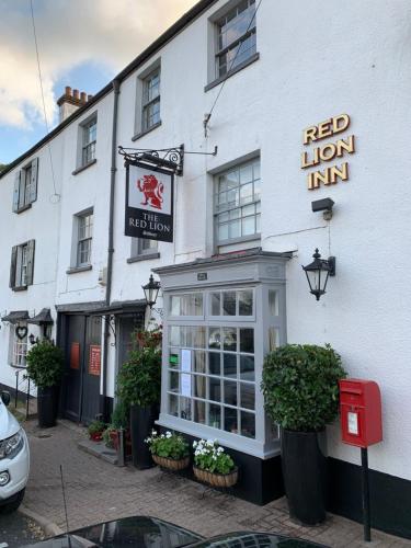 a white building with a red lion inn on a street at Red Lion Inn in Sidbury