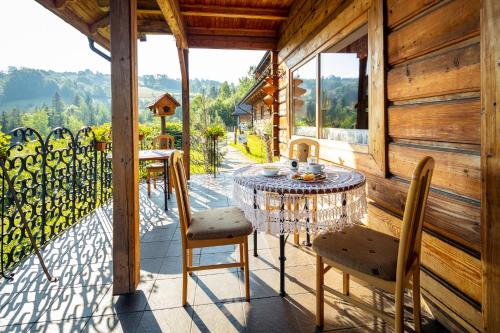 a table and chairs on the balcony of a cabin at Czarna Owca in Istebna