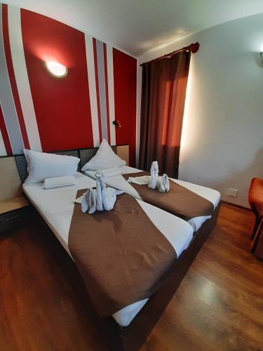 a hotel room with two beds with towels on them at Pensiunea Bianca in Murighiol