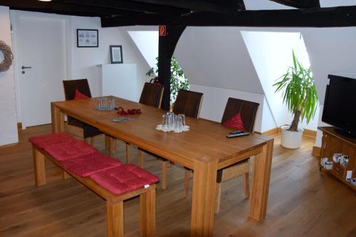 mesa de comedor de madera con sillas y TV en Haus Buuck - Herberge, en Rüthen