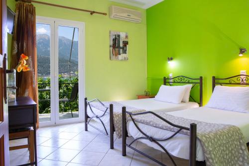 a bedroom with two beds and a green wall at Gialos in Yenion