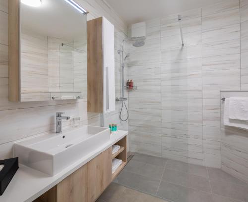 a white bathroom with a sink and a shower at Noemia Family Resort in Baška Voda