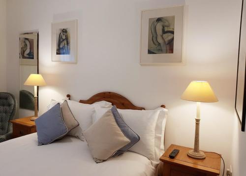 a bedroom with a bed with pillows and a lamp at Chy Bre in Truro