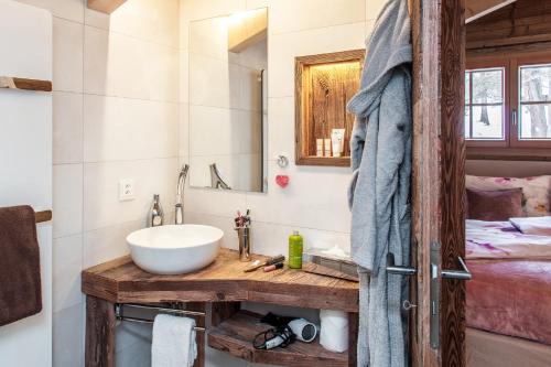 a bathroom with a sink and a mirror and a bed at Mountain Chalet 4 You in Zermatt