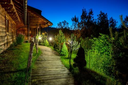 a wooden path leading to a house at night at Czarna Owca in Istebna