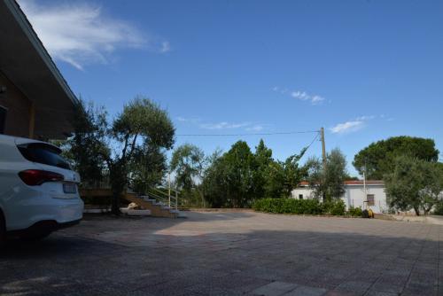 a white car parked in a parking lot at B&B Lara Santola in Corato