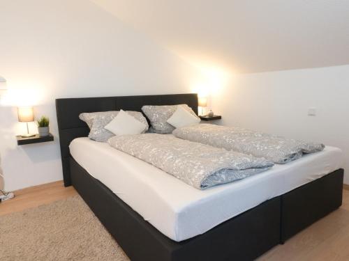 a black bed with white sheets and pillows on it at - NEU - LUXUS Frankfurt Flat in Obertshausen