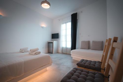 a white room with two beds and a couch at ZOE in Apollonia