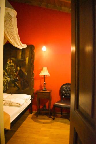 a bedroom with a bed and a chair and a lamp at Pension Anapli in Nafplio