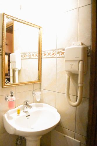 a bathroom with a white sink and a mirror at Pension Anapli in Nafplio